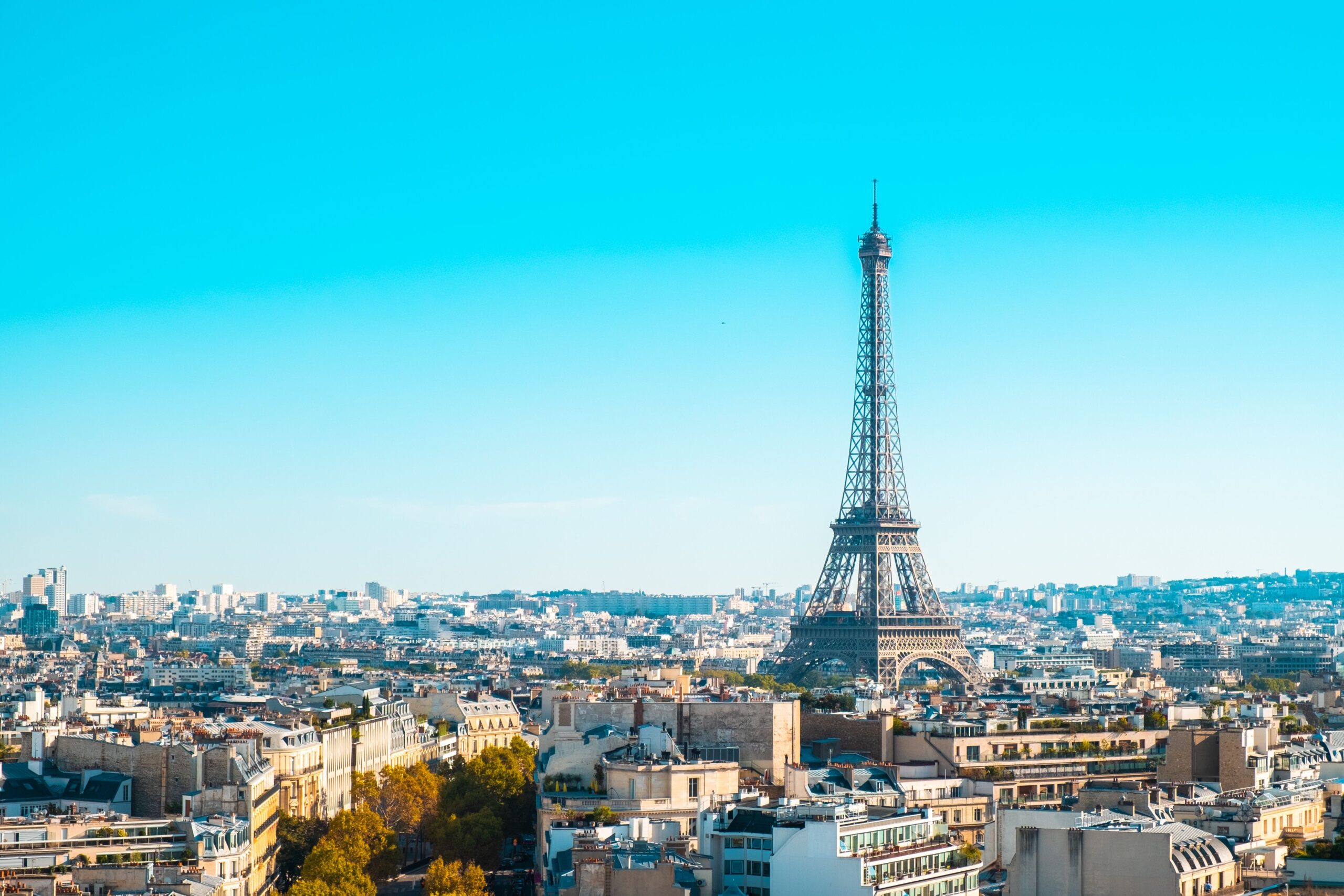 Eiffel Tower overlooking the cityscape of Paris under clear blue skies.