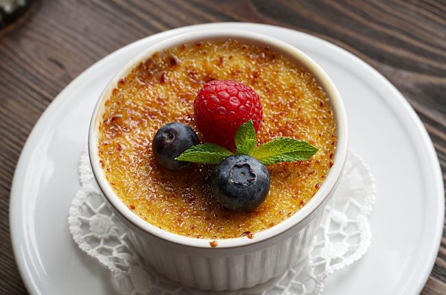 Delicious crème brûlée topped with fresh berries, perfect dessert idea.